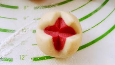 剩下的面剂，红色揉圆，白色擀开，白色面片把红面团包进去，光滑面朝上，用刀划十字口，做成了双色开花馒头。