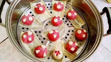 蒸锅添温水，把后做好的小猪放铺了玉米皮(也可用棉馏布、油纸等垫底防粘)的下层蒸架上，用手沾水甩水润皮。