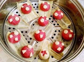 蒸锅添温水，把后做好的小猪放铺了玉米皮(也可用棉馏布、油纸等垫底防粘)的下层蒸架上，用手沾水甩水润皮。