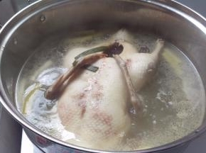 葱切小段，姜切片。把全鸭去水后烧一锅葱姜水（1/2姜和葱），煮沸以后加入鸭子，等到水沸腾后换中火煮50分钟。中间翻身1次（因为水盖不住全鸭子）。