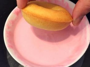 甜甜圈正面沾上粉色巧克力液