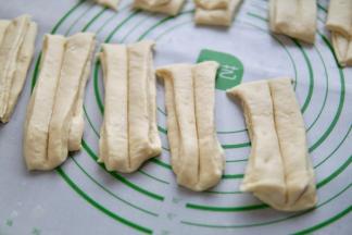 筷子沾面粉在中间压一条印子。如图