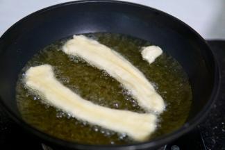 冷锅热油，大火烧热后转中小火开始炸油条，记得及时翻动油条