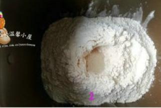把面包粉倒入，在面粉中央挖个小洞，把酵母放小洞内