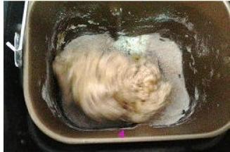 按启动键，开始揉面。揉面全程开着面包机盖子。