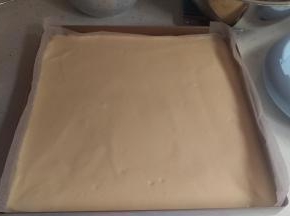 搅拌好后，倒入烤盘。用刮刀刮均匀。把烤盘从高处10CM，振它1-2次，让里面的汽泡出来。