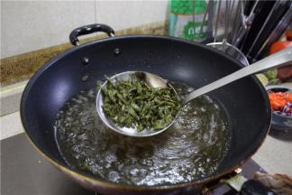 锅里烧油至7成油温，下入茶叶炸至定型，捞起