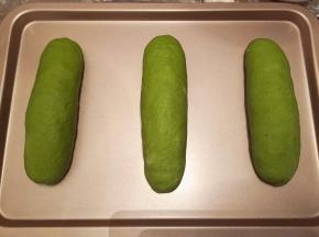 卷好的抺茶软欧胚放入烤盘，烤箱启动发酵功能，二发50分钟