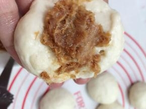 把松弛好的面团按压开，取适量的肉松