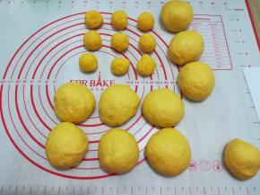 把面团分成一个50克搓圆用保鲜膜盖好松弛椰蓉分成一个15克搓圆备用