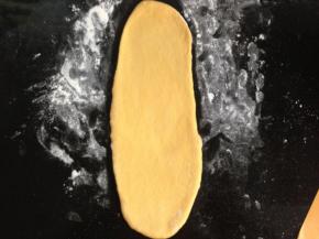 4、将松弛后的面团擀成椭圆形。