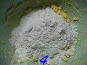 将低粉、泡打粉倒入打好的黄油蛋液中；