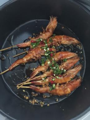 然后将葱花和红辣椒末放入虾身上