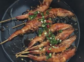 然后将葱花和红辣椒末放入虾身上