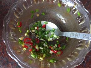 将葱花和红辣椒末放入调料碗中抹拌均匀