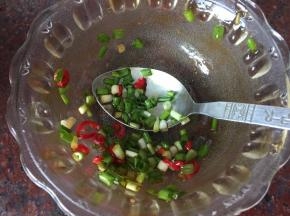 将葱花和红辣椒末放入调料碗中抹拌均匀
