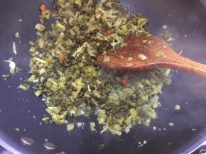 然后放入酸菜白芝麻一起翻炒，大概炒五分钟，然后滴入香油即可