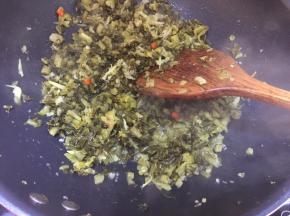 然后放入酸菜白芝麻一起翻炒，大概炒五分钟，然后滴入香油即可