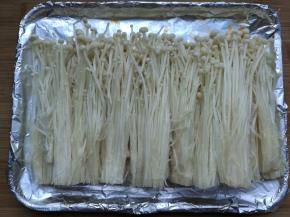 金针菇洗净去根用手撕开，排入铺了锡纸的烤盘内。