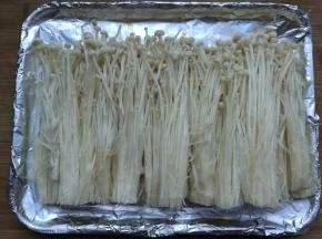 金针菇洗净去根用手撕开，排入铺了锡纸的烤盘内。