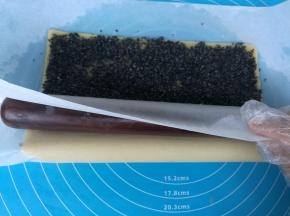 擀面杖放在靠近身体的一侧油纸下面。