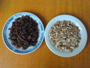 葡萄干用水浸泡3分钟，捞出，用厨房纸巾擦干，杏仁切成粒。