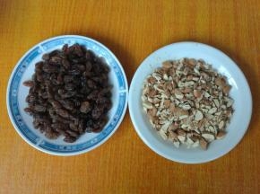 葡萄干用水浸泡3分钟，捞出，用厨房纸巾擦干，杏仁切成粒。