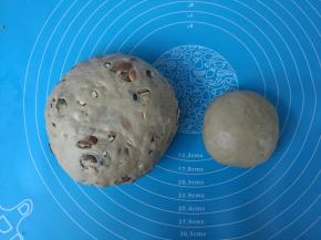 取出150克面团，剩下的面团和葡萄干、大杏仁揉在一起，分别揉圆，放在温暖的地方发酵。