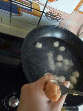 将锅中加水烧热，大家记住，是烧热不是烧开，将肉馅挤成丸子，放入锅中煮至成熟。