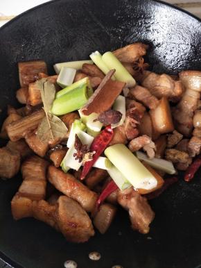 放入葱 姜 八角 桂皮 干辣椒，继续翻炒，炒到肉颜色稍微变深一点