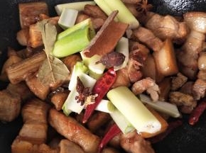放入葱 姜 八角 桂皮 干辣椒，继续翻炒，炒到肉颜色稍微变深一点
