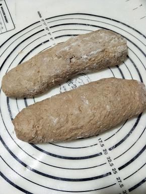 取一份面团，拍扁，法棍的整形手法，整理好，再松弛20分钟左右。松弛后，轻拍面团，整理成长方形，松弛30分钟。松弛好后， 用手指在面团表面戳一排，然后刷上橄榄油，可以可以自己的喜欢，撒上香草和芝麻。