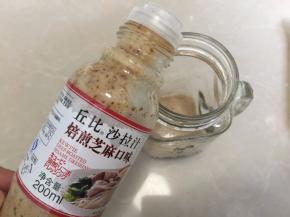 沙拉罐里倒入丘比芝麻沙拉汁