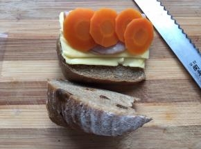 然后取一片芝士片，放入火腿片、胡萝卜片