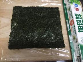 保鲜膜铺在菜板上，然后放入两片紫菜片