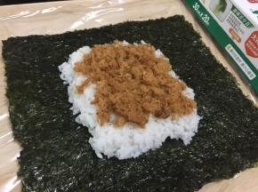 在米饭上铺上自制的肉松