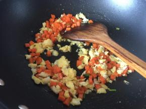 然后放入切粒的胡萝卜炒