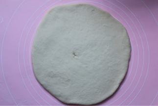 面团拿出来放在揉面垫上，擀成片，大小跟9寸烤盘大点就好