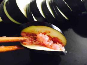 放入约7成满的调好的肉馅。在这步我们有一个小窍门，就是在茄盒的内部抹上一层薄薄的干淀粉，能更好的粘合茄盒。