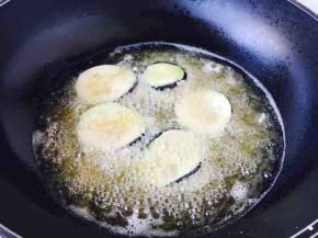 开大火置不粘锅，锅热后放半锅油，当油5、6成热时放适量的茄盒，此时转中小火。提醒小伙伴们一下，油温不能太高，如果太高容易外焦内生；油温在炸茄盒时油温变化很大，要随时调节火的大小，避免油冒烟。