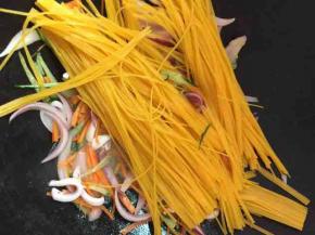 放入玉米面条翻炒片刻，撒少许水，防止粘锅，