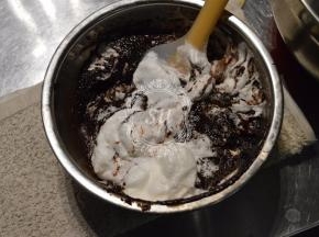 先取1/3的蛋白加入到巧克力糊中，，翻拌均匀。再加入剩余蛋白的1/2继续翻拌均匀。最后将巧克力糊倒入剩余的蛋白中快速翻拌均匀至有光泽且看不到