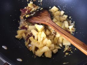 然后将切小块的凤梨放入锅中炒