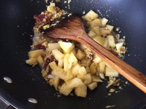 然后将切小块的凤梨放入锅中炒