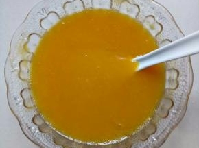 把融化的吉利丁片加入芒果汁里混合均匀
