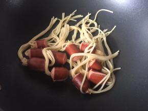 然后将沥干水份的穿肠意面放入锅里将热锅肠煎香，因为煮的时候热锅肠被煮得没有那么香了