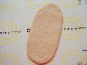 面团放垫子上排气，平均分成4份。取一份擀成长条面片。