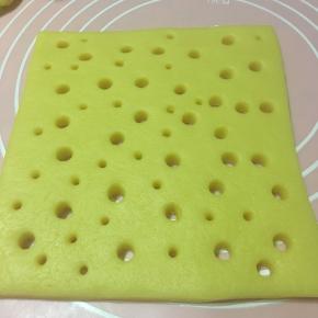 面团擀成5MM厚的片状,用粗细二种吸管随意戳出孔