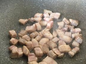 五花肉下锅炒至微黄，加少许料酒和半汤匙生抽。