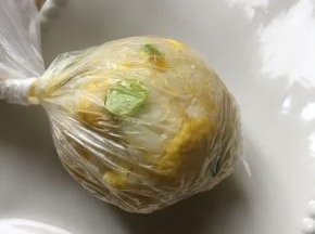 取一勺饭团,放保鲜膜中揉圆装盘.盖上芝士片